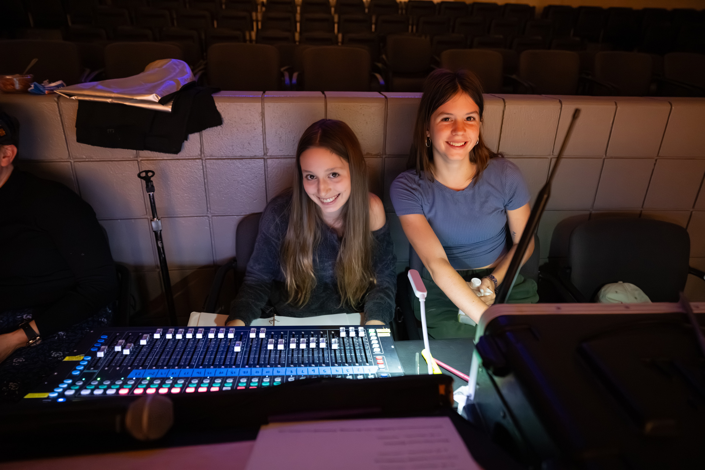 Two students sitting at a sound mixing board